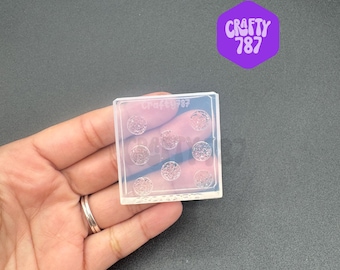 May include: Clear silicone mold with nine circular impressions. The mold is designed for creating small resin crafts.