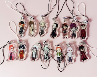 Może przedstawiać: Kolekcja piętnastu przezroczystych akrylowych zawieszek przedstawiających różne postacie w stylu anime chibi. Każda zawieszka jest przymocowana do cienkiej czarnej lub białej pętli ze sznurka z metalowym zapięciem. Postacie mają różnorodne stroje i pozy.