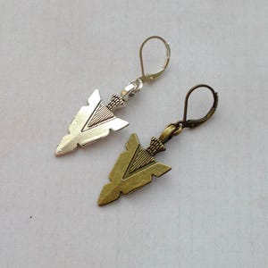 May include: A pair of silver and bronze arrowhead earrings. The earrings have a simple design and are perfect for everyday wear.
