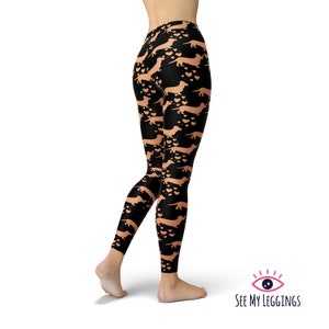 May include: Black leggings with a repeating pattern of orange dachshund dogs and hearts.
