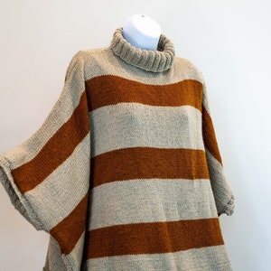 Hand knit winter turtle neck poncho/shawl in sand color with cognac straps. Rectangular form with sleeves.