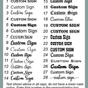 May include: A selection of 28 "Custom Sign" font styles in various designs, from classic to modern, displayed on a light background. The text is shown in all caps, with instructions to enter the font number in the personalization box.