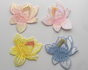 May include: Four embroidered iron-on patches featuring lotus flowers in pink, yellow, and blue.