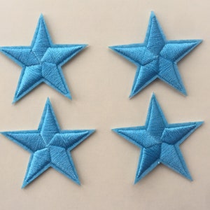May include: Four light blue felt star-shaped patches. Each star is approximately 5 cm wide.