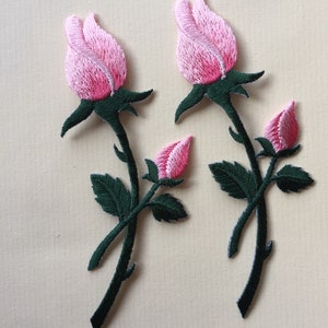 Può includere: Toppe ricamate a forma di rosa con boccioli e fiori rosa aperti, steli e foglie verdi. Queste toppe sono ideali per aggiungere accenti floreali a vestiti, borse o altri articoli in tessuto. Le toppe hanno un aspetto strutturato.