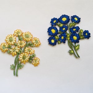 Könnte beinhalten: Zwei gestickte Blumenpatches, einer mit gelben Blumen und einer mit blauen Blumen. Beide Patches haben grüne Stiele und Blätter.