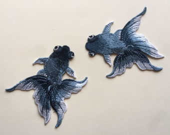 Un par de parches bordados cosidos con peces de color gris Insignia con apliques