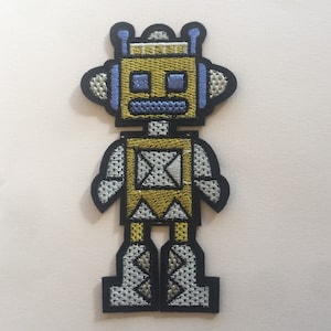 May include: A yellow and white robot with blue eyes and antennas. The robot is wearing a yellow and white suit and has black boots.