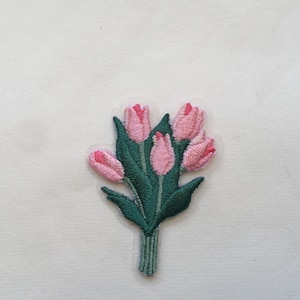 Könnte beinhalten: Ein gestickter Aufnäher mit einem Strauß aus fünf rosa Tulpen mit grünen Blättern.