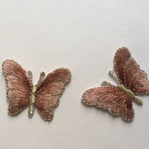 May include: Two brown embroidered butterfly patches with gold accents.