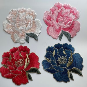 May include: Four embroidered fabric patches featuring a peony flower design. The patches are in pink, white, red, and blue.