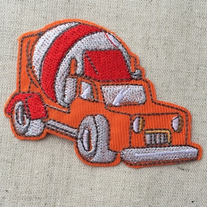 May include: Orange embroidered iron-on patch of a cement mixer truck. The truck has a red cab and a gray cement mixer drum.