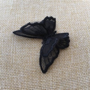 May include: Black lace butterfly applique. The butterfly has a delicate, intricate design and is perfect for adding a touch of elegance to any project.