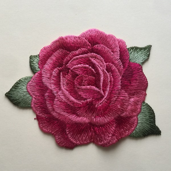 Fleurs roses cousues sur un patch brodé complet avec appliqués