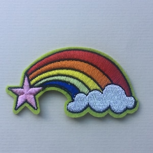 May include: An embroidered patch featuring a rainbow with a pink star and a white cloud. The patch is on a light green background.