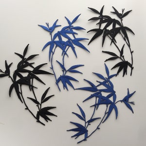 May include: Embroidered bamboo leaf patches in black and blue. The patches feature detailed leaf designs and are arranged on a white background. These patches are suitable for fabric crafts and DIY projects.