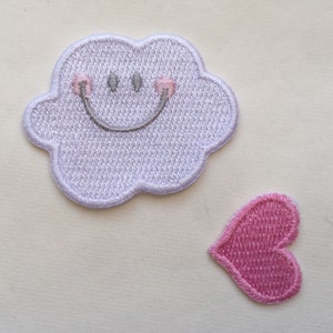 May include: Two embroidered iron-on patches. One is a white cloud with a smiling face and pink cheeks. The other is a pink heart.