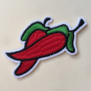 Könnte beinhalten: Gestickter Chili-Pfeffer-Patch in Rot und Grün. Der Chili-Pfeffer ist eingerollt und hat einen weißen Umriss.