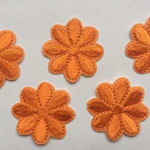 Puede incluir: Cinco parches de flores de fieltro naranja, cada uno con ocho pétalos y un círculo central. Los parches son perfectos para agregar un toque de fantasía a la ropa, las bolsas u otras manualidades.