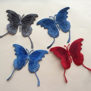 May include: Embroidered butterfly patches in blue, red, and grey. Each butterfly features detailed wing patterns and delicate antennae. These patches are suitable for clothing, accessories, or craft projects.