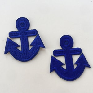 Puede incluir: Dos parches de ancla de fieltro azul. Las ancras son de diseño tradicional con una barra transversal y dos puntas en la parte inferior.