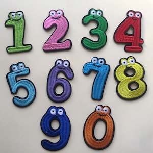 May include: Ten colourful felt patches shaped like numbers with cartoon faces. The numbers are 1, 2, 3, 4, 5, 6, 7, 8, 9, and 0.