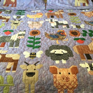 Può includere: Un set di biancheria da letto con animali della fattoria. La trapunta lavanda presenta animali della fattoria applicati, tra cui cavalli, mucche, pecore e maiali. Il set include due federe con disegni di cavalli. La trapunta ha un bordo di girasoli e fiori.