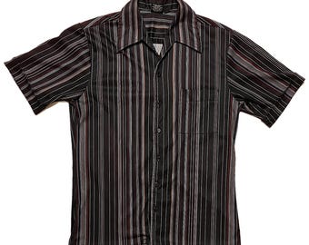 Pode incluir: Camisa de manga curta com botões e listras verticais em preto, bordô e branco. A camisa tem um bolso no peito e uma gola clássica. O tecido parece ser leve.