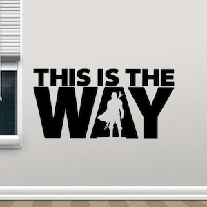 Könnte beinhalten: Schwarz-weiße Wanddekoration mit dem Text "This is the Way" und einer Silhouette einer Person, die eine Waffe hält.