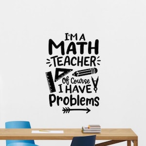 Könnte beinhalten: Schwarz-weißer Wandaufkleber mit dem Text "I'M A MATH TEACHER Of Course I HAVE Problems" und mathematischen Grafiken. Enthält ein Lineal, ein Dreieck, einen Bleistift und einen Pfeil. Der Aufkleber befindet sich an einer weißen Wand über einem Holztisch.