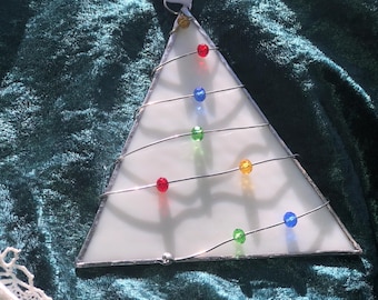 May include: White glass Christmas tree ornament with a wire frame and colorful glass beads. The ornament is hanging from a white ribbon.