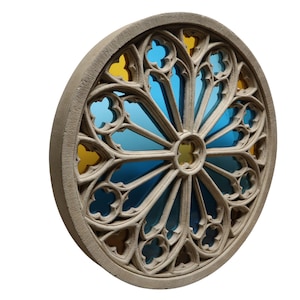 May include: A round, beige stone architectural element with a stained glass design. The stained glass features blue and yellow sections, creating a vibrant contrast. The design is symmetrical, with a central circular element and radiating patterns.