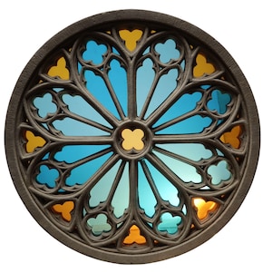 May include: Circular stained glass window with a dark gray frame. The window features a symmetrical design with blue, yellow, and orange glass panes. The central design is a four-leaf clover shape. The background is a bright blue.