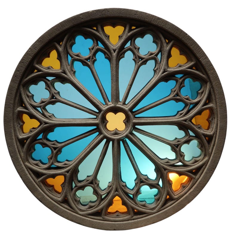 May include: Circular stained glass window with a dark gray frame. The window features a symmetrical design with blue, yellow, and orange glass panes. The central design is a four-leaf clover shape. The background is a bright blue.