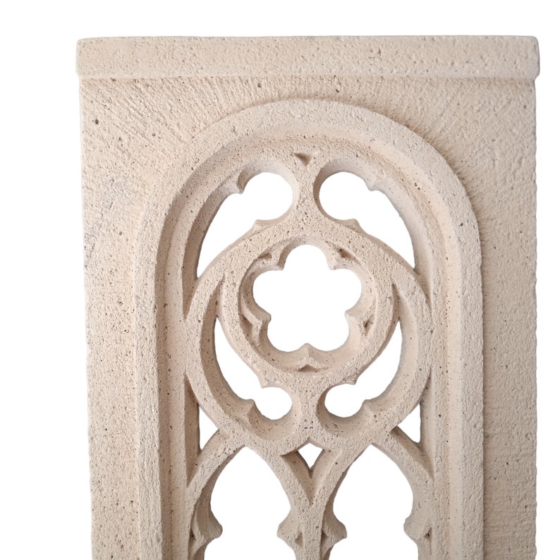 May include: A white stone archway with a decorative, intricate design. The archway is made of a rough, textured stone and has a light, airy feel.