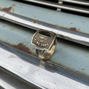 Upcycled car key ring on mechanic glove by a classic truck — handmade statement piece for hot-rod fans and garage culture.