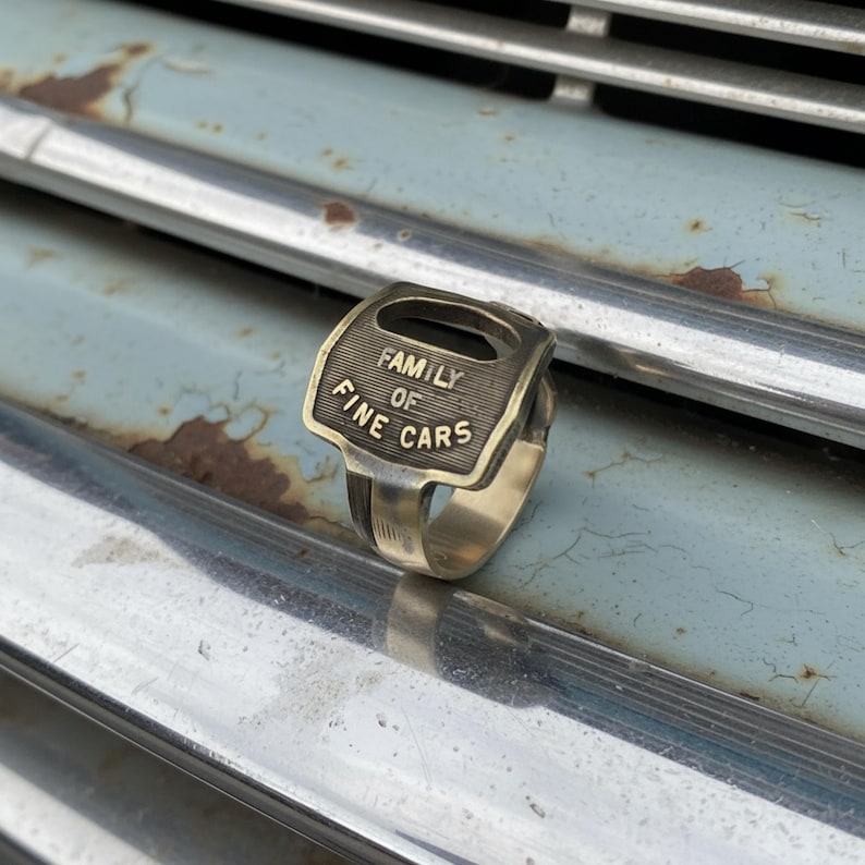 Upcycled car key ring on mechanic glove by a classic truck — handmade statement piece for hot-rod fans and garage culture.