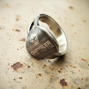 Upcycled car ignition key ring on textured surface — handmade sustainable statement jewelry for mechanics and car lovers.