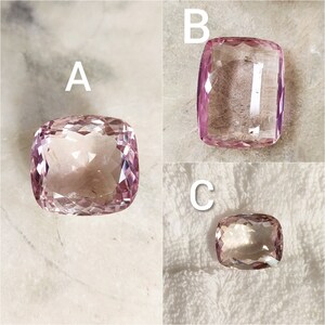 May include: Three pink cushion-cut gemstones labeled A, B, and C. The gemstones are faceted and have a translucent appearance.