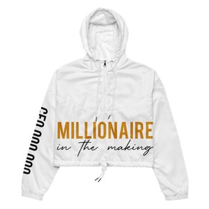 May include: White cropped windbreaker jacket with a gold "MILLIONAIRE in the making" text on the front and black "CEO" text on the sleeve.