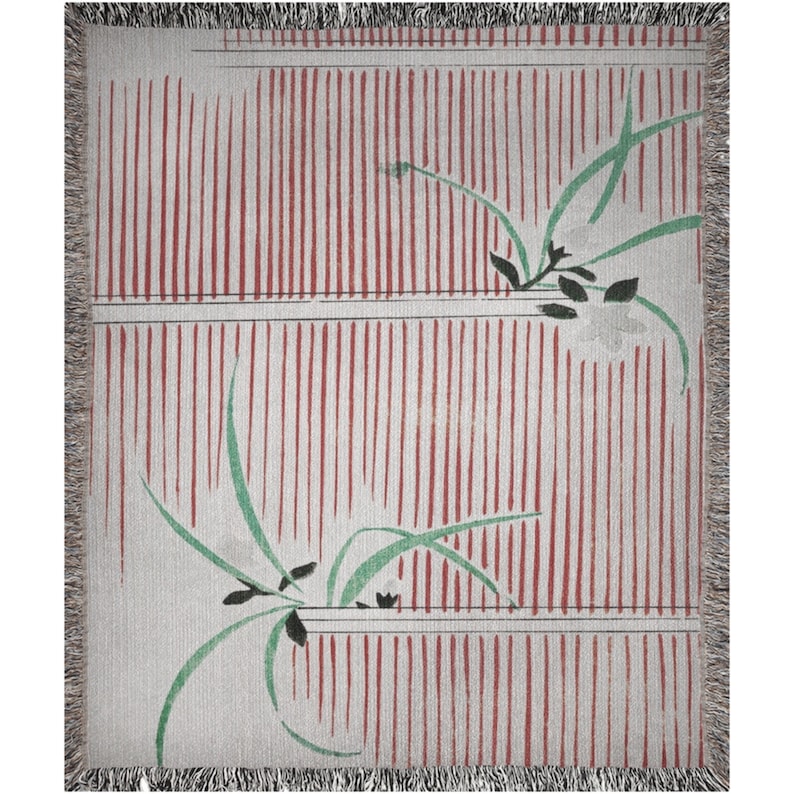 Pode incluir: Uma manta tecida com um padr&atilde;o de listras vermelhas e brancas e um design floral verde. A manta tem uma borda de franjas.