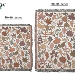 May include: Two woven throw blankets with a fall leaves pattern. The smaller blanket is 50x60 inches, and the larger one is 60x80 inches. The blankets feature a cream background with brown, orange, and green leaves and fringe.