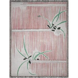 Pode incluir: Uma manta tecida com fundo branco e listras vermelhas. A manta apresenta um design floral estilizado em verde e branco.
