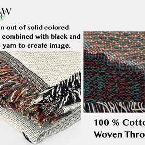 May include: A folded woven throw blanket with a textured surface. The blanket is made of solid colored yarns combined with black and white yarn. The edges have colorful fringe. The text "100% Cotton Woven Throw" is visible.