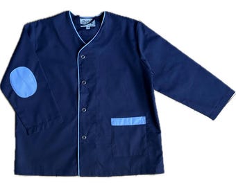 May include: A navy blue long-sleeved jacket featuring a V-neckline with light blue piping trim. The garment includes four silver-toned snap buttons, a single chest pocket with a light blue accent, and a light blue oval elbow patch on the sleeve.