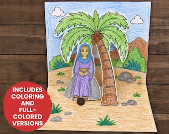 May include: A pop-up paper craft featuring Deborah the Judge sitting under a palm tree. The scene includes a desert landscape with mountains, rocks, and shrubs. A red circular badge states: INCLUDES COLORING AND FULL-COLORED VERSIONS.