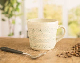 Handmade pottery half pint mug, rustic pottery mug with blue slip decoration.