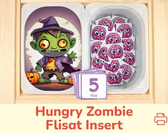 May include: A wooden box with a removable insert for a counting game. The insert has a picture of a green zombie wearing a witch's hat and holding a pumpkin. The box also has a compartment with pink brain-shaped counters and a card with the number "5" and the word "five" written on it.