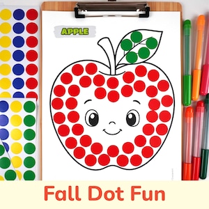 May include: A dot marker activity sheet on a clipboard featuring a cartoon apple with a smiling face. The apple outline is filled with red circular stickers, and the leaf is filled with green stickers. Sheets of colorful dot stickers and markers are nearby.