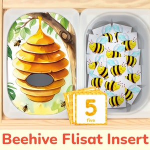 May include: A wooden beehive-shaped Flisat insert with a yellow and brown beehive image on one side and a white tray with 15 yellow and black bee images on the other side. The tray also includes a yellow card with the number 5 and the word "five" written on it.